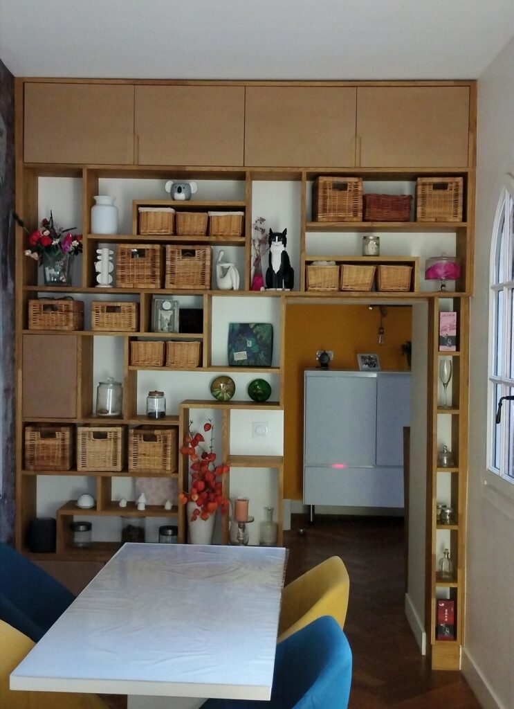 Bibliothèque déstructurée en chêne lamellé collé avec porte de passage intégrée, composition asymétrique sur mesure