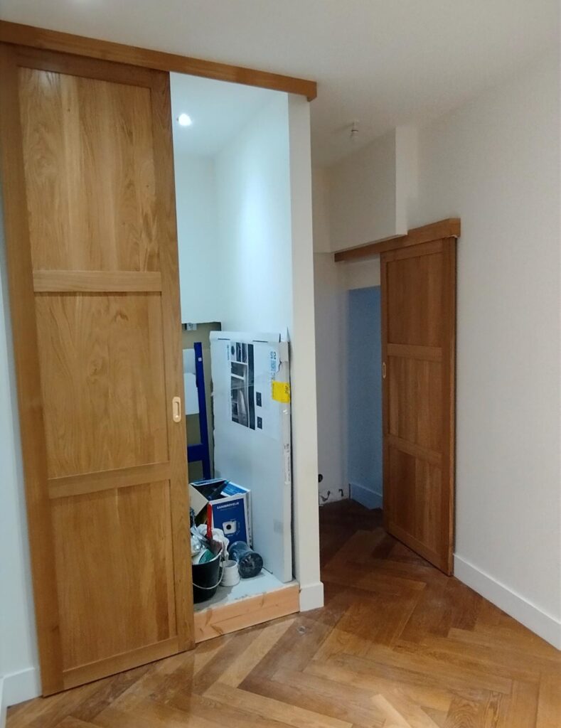 Porte à galandage en chêne massif installée dans une chambre rénovée à Toulouse.