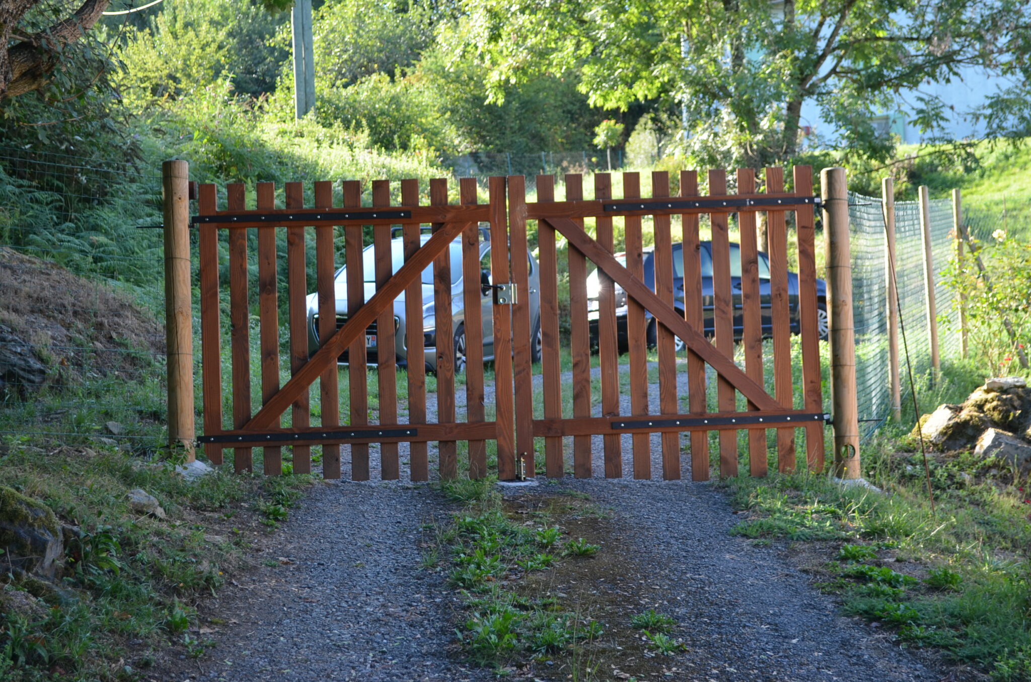 Détail du portail en douglas avec poteaux bois et clôture grillagée, posé à Aspet