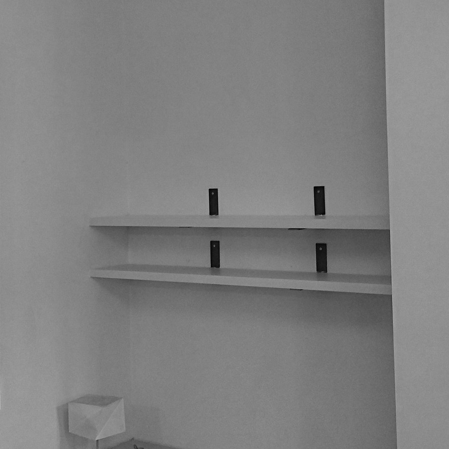 Étagères sur mesure en stratifié blanc fixées au mur avec équerres Gustav et tasseaux invisibles