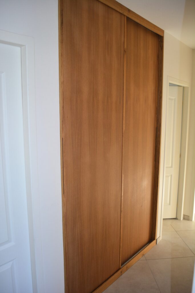 Portes coulissantes en chêne sur mesure dans un couloir à Gagnac-sur-Garonne, aménagement de placard avec habillage en bois massif